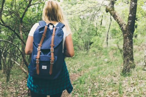 hiker with blue backpack and blue plaid shirt