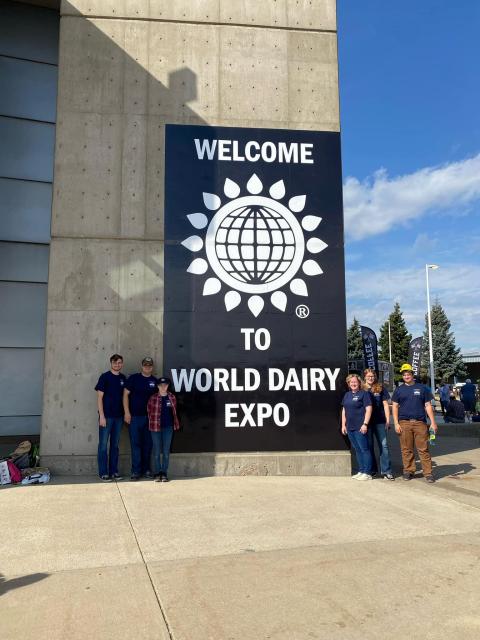 group of kids in front of a banner that reads "Welcome to World Dairy Expo"