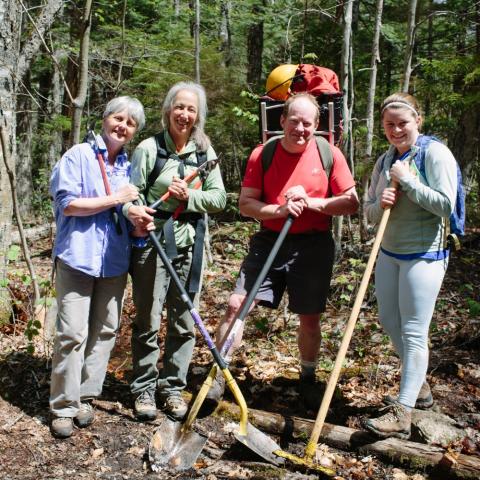 Trail maintenance volunteers holding shovels