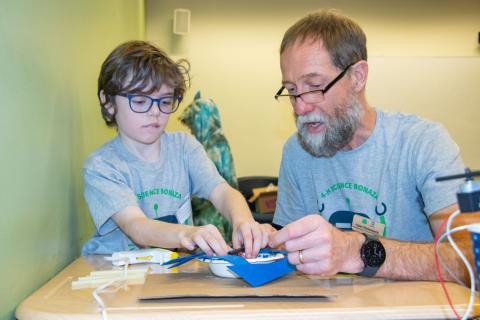 Adult and child working on a STEM project in classroom