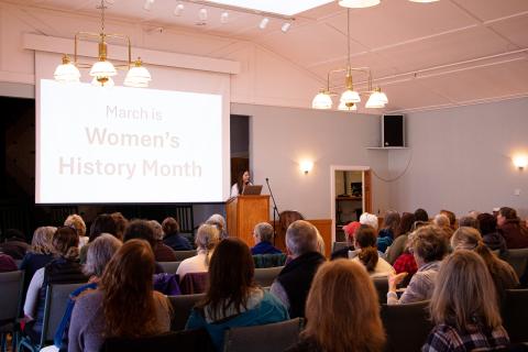 an audience of women watching a presentation
