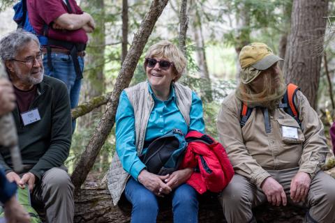 participants smiling while sitting on rocks