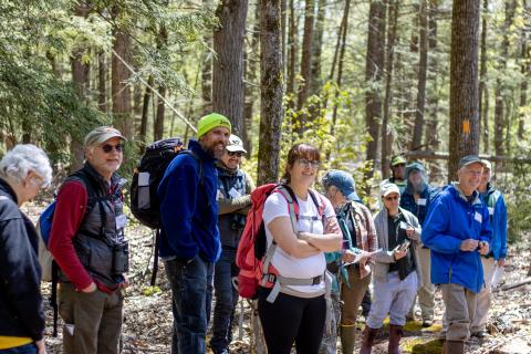 participants standing in a line in the woods smiling