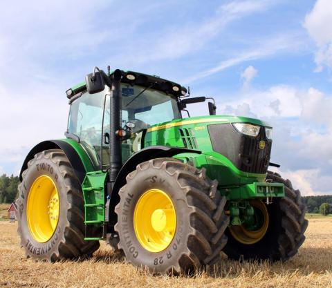 green tractor in hay field