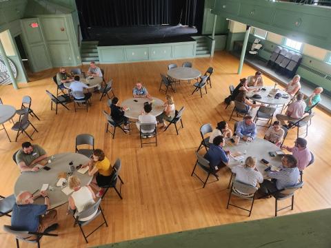 overhead view of small groups talking at tables in exeter town hall