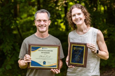 a man and a women holding award plaques