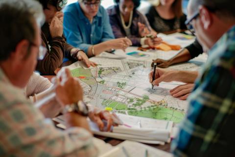 A group of people sitting over a planning map.