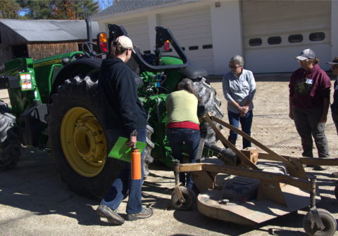 Women standing around a large tractor