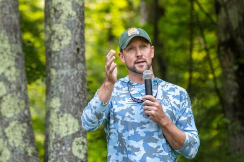 Man speaking outdoors with microphone