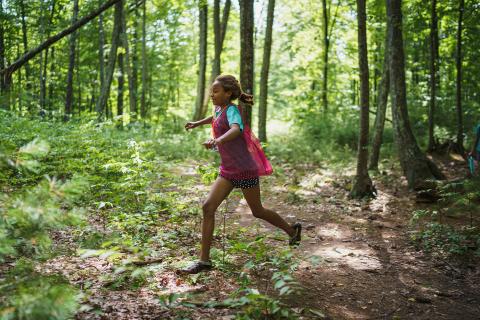 Girl running through forest