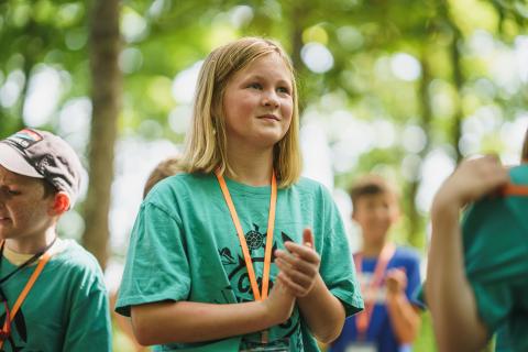 Camper clapping hands while in forest