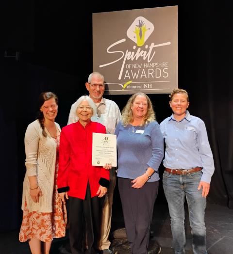 Group of people on stage, accepting award