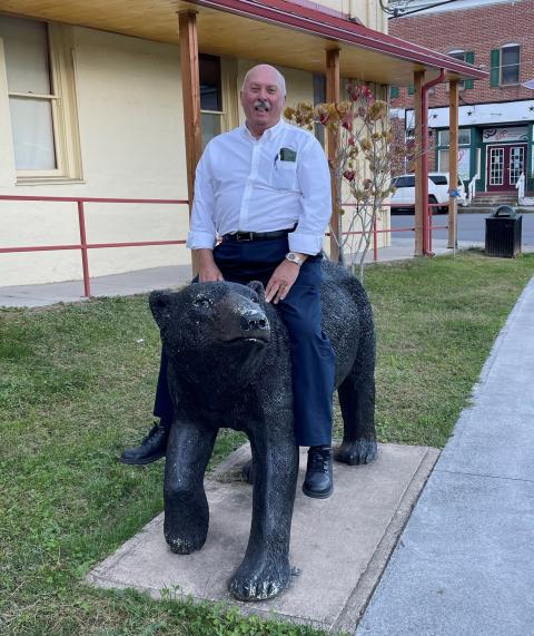 A man sitting astride a black bear statue