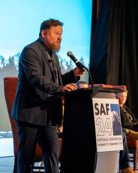 Man speaking at podium on stage