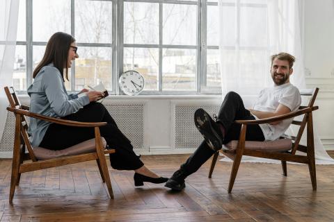 1 Female and 1 Male adult sitting and laughing