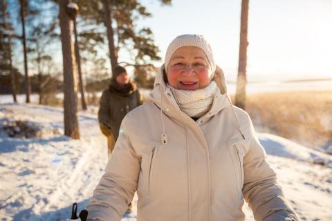 Senior woman and man hiking in cold forest. 