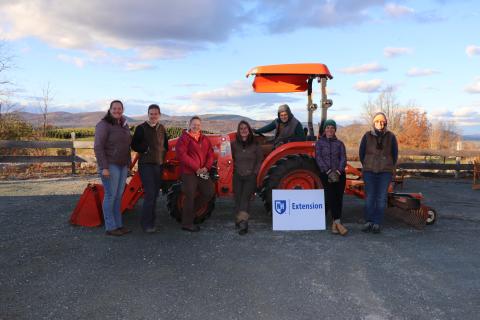 Women standing in front of tractor with UNH Extension sign