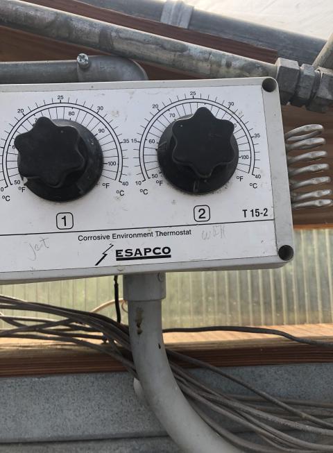 Close up of climate control dials in a greenhouse.