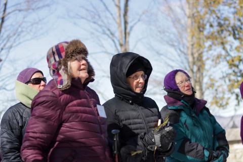 four women standing in a line smiling