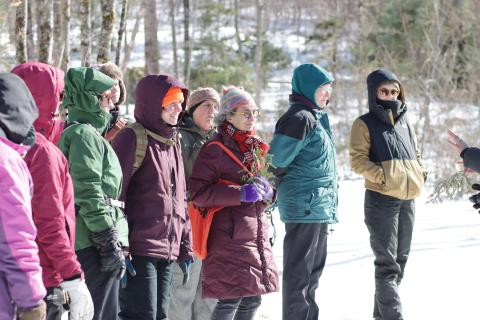 nine women standing in a line outside during the wildlife tracking session