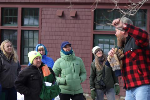 a group of women learning how to identify a sugar maple by looking at the tree buds