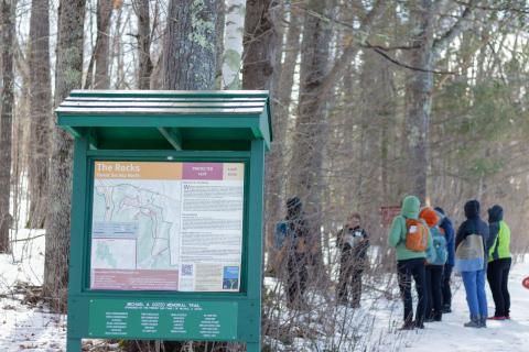 a group of women standing outside identifying trees