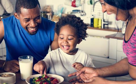 Black family eating healthy food together.