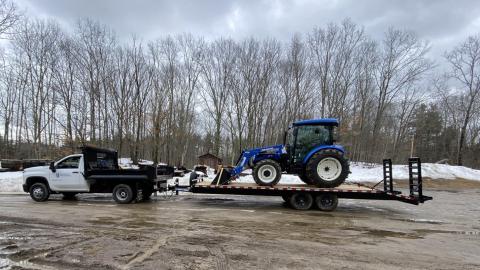 Tractor on trailer being pulled by a truck