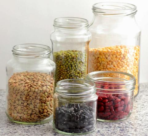 5 open canning jars containing dried beans, lentils, and corn kernels