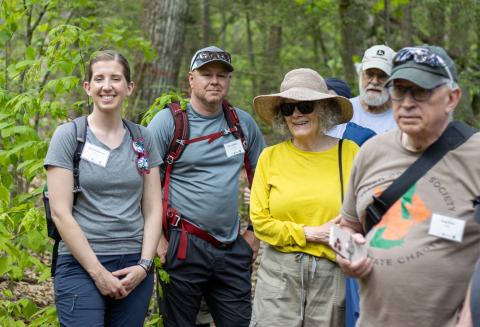 5 people smiling in the woods while learning about wildlife