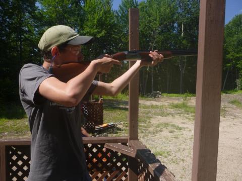 Youth aims shotgun towards target