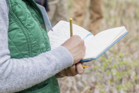 a woman's hand writing in a journal