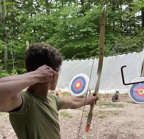 Youth shooting a bow at an archery target
