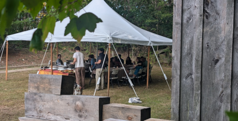 students under a tent getting food