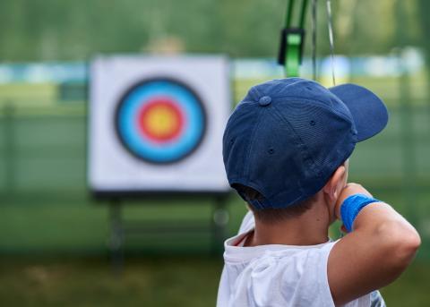 A boy shooting an arrow at a target