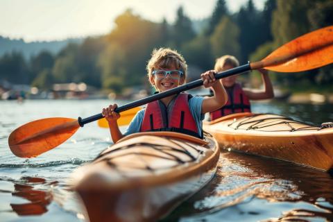 2 boys in canoes on a lake