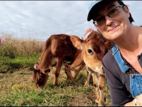 Woman with two cows in a field