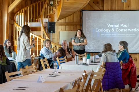 women sitting inside watching a presentation about vernal pools