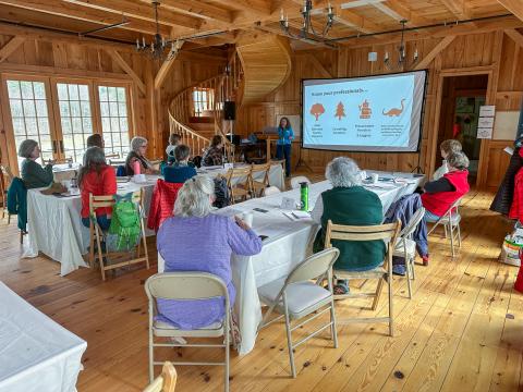 a group of women sitting inside listening to a presentation