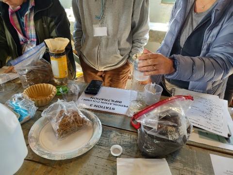 people holding samples at a soil testing station