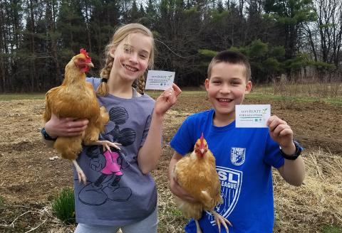 4-H siblings hold up chickens