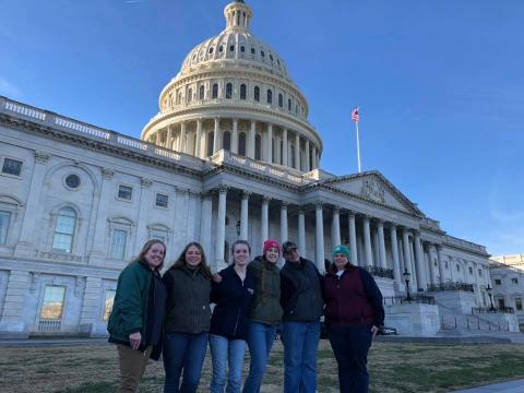 6 people in front of large congressional building