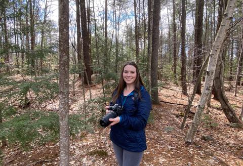 Amy Arsenault poses in the woods with her camera