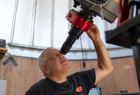 John Gianforte looks through a telescope to study astronomy in the UNH Observatory