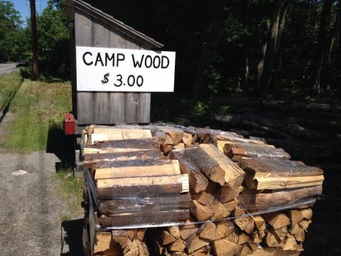 bundles of camp firewood for sale along a road; photo by Liz Graves, Mount Desert Islander