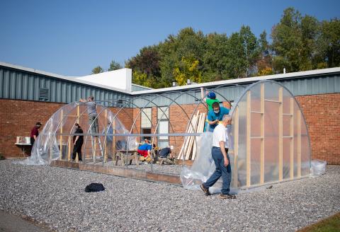 Volunteers assisting with construction of a hoop house 