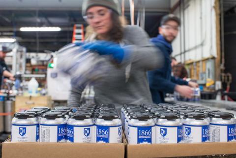 N.H. beer being packaged on an assembly line.