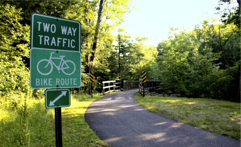 Bike route sign in front of bridge