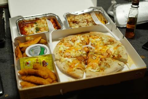big to-go box of pizza and side dishes