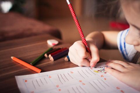 child coloring with pencil